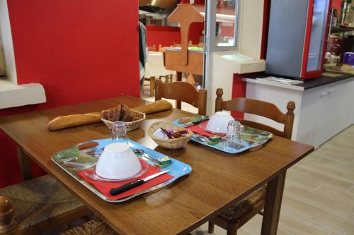a wooden table with two plates of food on it at Au Petit Bonheur in La Tranche-sur-Mer