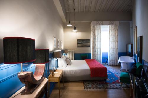 フィレンツェにあるアドアストラスイーツのベッドルーム1室(ベッド1台、ランプ2つ付きのテーブル付)