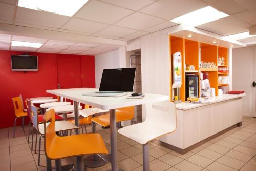 an office with a table and chairs with a laptop on it at Première Classe Dijon Nord - Zénith in Dijon