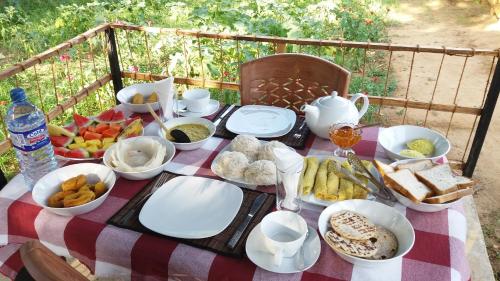 a picnic table with food on a checkered table cloth at Sigiriya Amenity Home Stay in Sigiriya