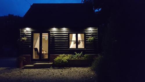 a small house with lights on the front of it at The Cartlodge B & B in Colchester