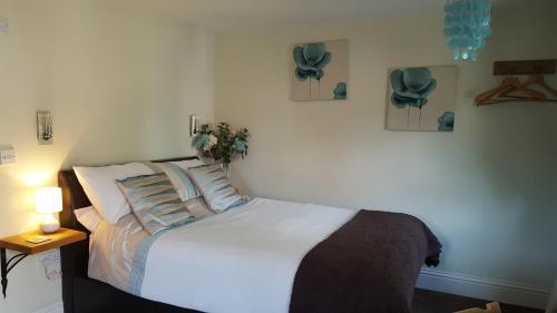 a bedroom with a white bed with pillows at The Cartlodge B & B in Colchester