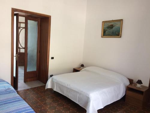 a bedroom with a white bed and a mirror at The Reef House in Pozzuoli