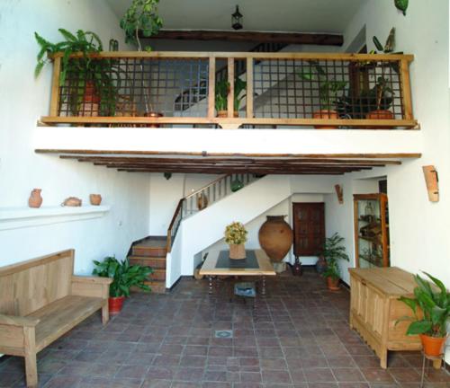 a patio with two benches and a staircase with plants at Casa Rural Las Avutardas in Sierra de Fuentes
