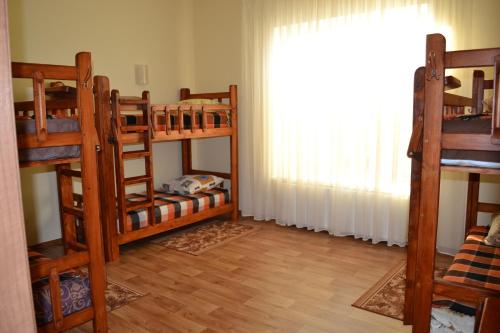 a room with three bunk beds and a window at Hostel Korona in Verbovatovka