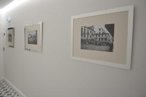 a row of framed photographs on a white wall at Edificio Charles 103 in Funchal