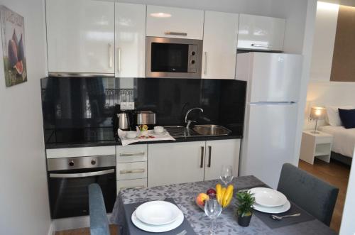 a kitchen with white cabinets and a table with a tableablish at Edificio Charles 103 in Funchal