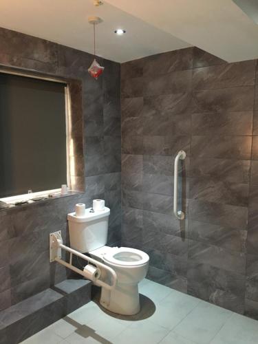 a bathroom with a toilet and a shower in it at Park Avenue Inn Craven London Hyde Park in London