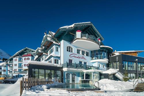 a large white building with snow on the ground at Sporthotel Cinderella in Obertauern