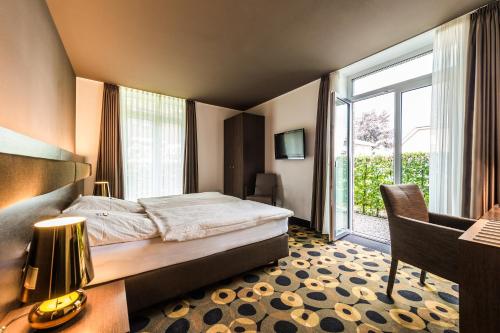 a bedroom with a bed and a desk and a window at Hof Veldink in Emlichheim