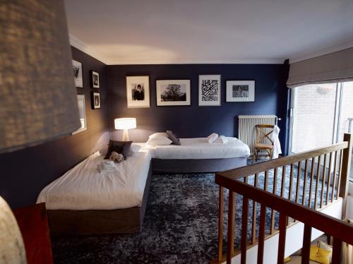 two beds in a room with blue walls at Landgoed De Holtweijde in Lattrop