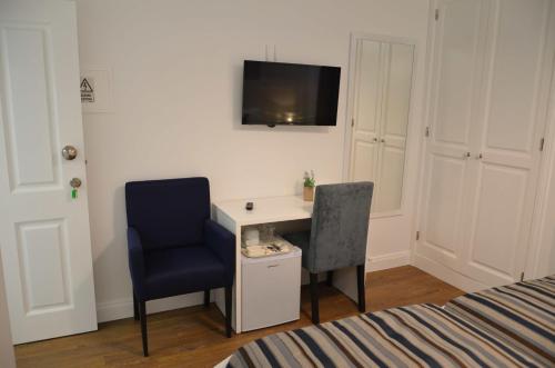 a bedroom with a desk and a chair and a tv at Edificio Charles 206 in Funchal