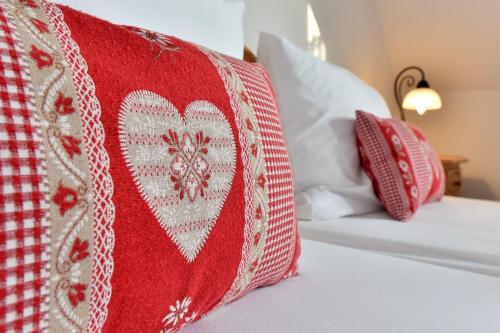 a bed with a red and white blanket on it at Landhotel Jungbrunnen in Bad Brambach