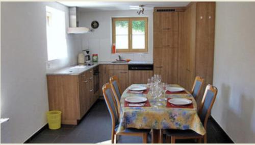 een keuken met een tafel en stoelen en een keuken met een tafel en een stoeltje bij Chalet Schönbühl in Mürren