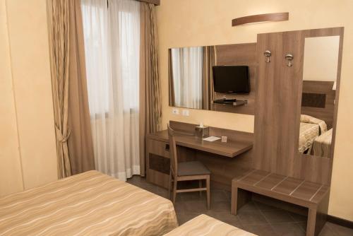 a hotel room with a desk and a mirror at Hotel Corte Business in Cavriago