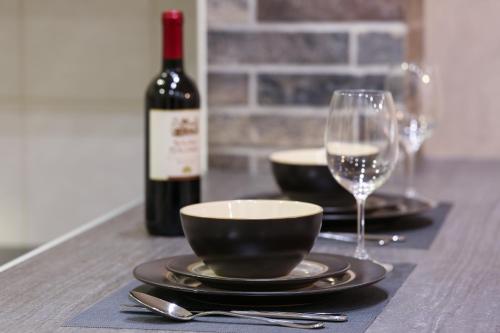 a table with a bottle of wine and a wine glass at Apartment Promenada in Novi Sad