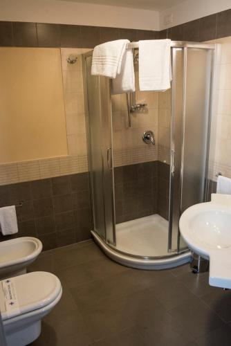 a bathroom with a shower and a toilet and a sink at Hotel Corte Business in Cavriago