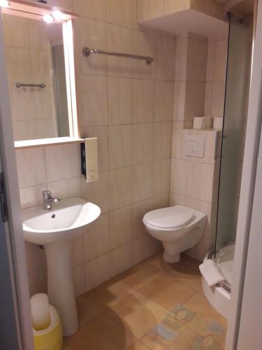 uma casa de banho com um lavatório e um WC em Hotel Paola em Kutno