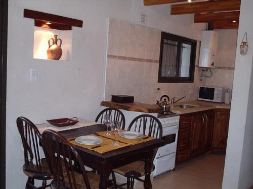 eine Küche mit einem Holztisch mit Stühlen, einem Tisch und einem Tisch in der Unterkunft El Solar in La Bolsa