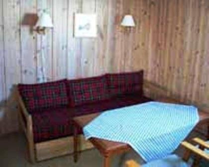 a living room with a red couch and a table at Kvanhøgd Turistsenter in Gol