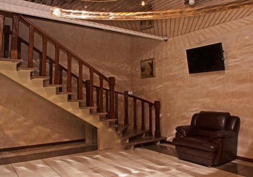 a living room with a chair and a staircase at SV Park Hotel in Kharkiv