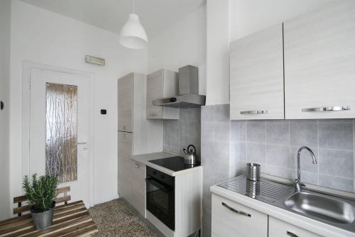 a white kitchen with a sink and a stove at MC Guest House in Rome