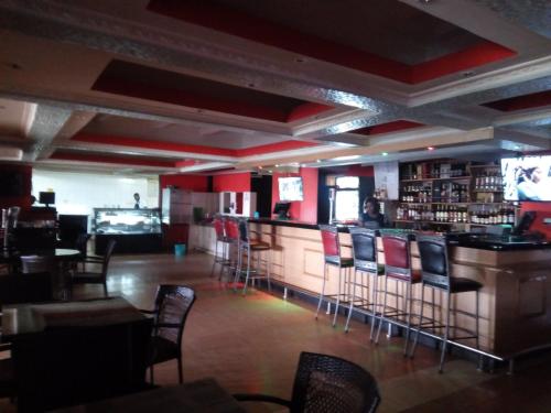 a bar in a restaurant with chairs and a counter at Marcia Hotel Nairobi in Nairobi
