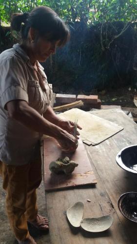 a woman working on a pair of shoes on a table at Hostal Las Palmas in Puyo