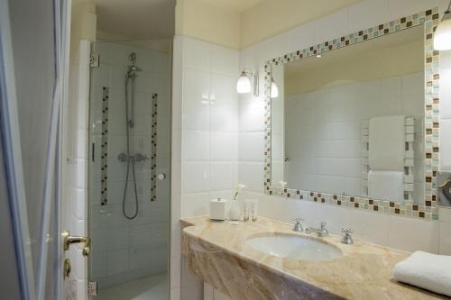 a bathroom with a sink, mirror, and bathtub at Hôtel Brighton - Esprit de France in Paris