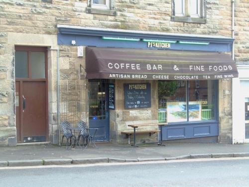 a coffee bar and fine foods store on the street at Snug - Krayr Apartment in Helensburgh
