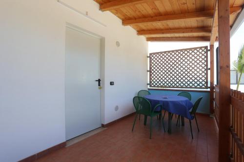 a dining room with a blue table and green chairs at Camping Lido di Salerno in Pontecagnano