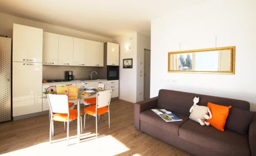 uma sala de estar com um sofá e uma mesa com cadeiras em Suite dei Fabbri em Mezzegra