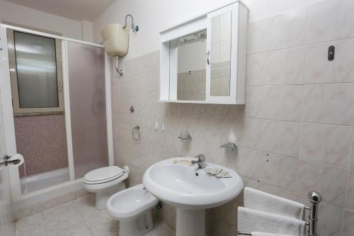 a bathroom with a sink and a toilet and a mirror at Camping Lido di Salerno in Pontecagnano