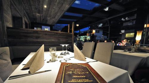 a table with a napkin on a table in a restaurant at Hotel Des Alpes in Selva di Val Gardena