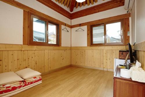 a large room with wooden floors and windows and a bed at Nadle Bang in Jeonju
