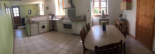 a kitchen with a table and chairs and a kitchen with a stove at Korshøjgårds Bed og Breakfast in Herlufmagle
