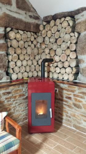 a fireplace in a room with a pile of logs at Casa da Avó Ana Alvão in Bilhó