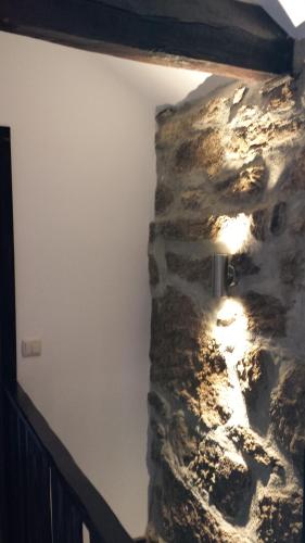 a room with a stone wall with a light on it at Casa da Avó Ana Alvão in Bilhó