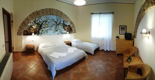 a bedroom with two beds and a painting on the wall at Farmstay La Morella in Battipaglia