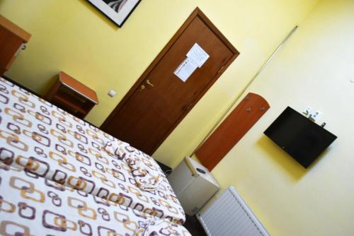 a bedroom with a bed and a wooden door at Pensiunea Nicolas in Craiova