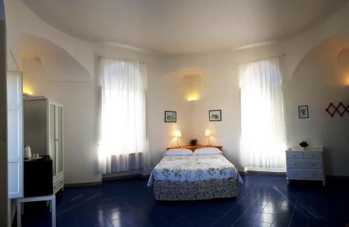 a bedroom with a bed and two windows at Farmstay La Morella in Battipaglia