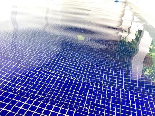 una piscina con azulejos azules en el suelo en Casa Verde Albarrada en Mompox