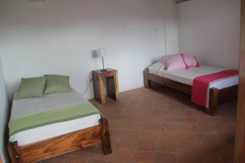 1 dormitorio con 2 camas y mesita de noche en Casa Verde Albarrada en Mompox