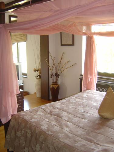 a bedroom with a bed with a pink canopy at Resort Bali Spa in Cornu de Jos