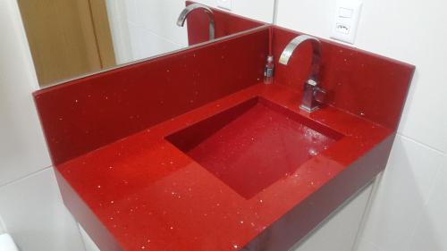 lavabo rojo en el baño con espejo en Apartamento 601 3 Dormitórios, en Torres