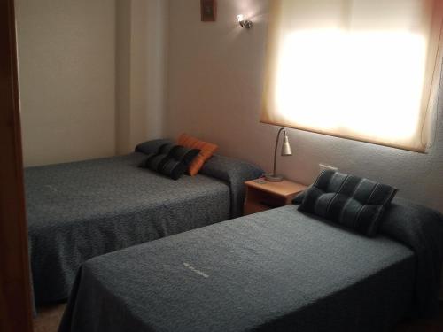 Posteľ alebo postele v izbe v ubytovaní Hostal Arneva Orihuela
