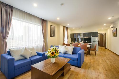 ein Wohnzimmer mit einem blauen Sofa und einem Tisch in der Unterkunft Central Hotel & Spa Danang in Đà Nẵng