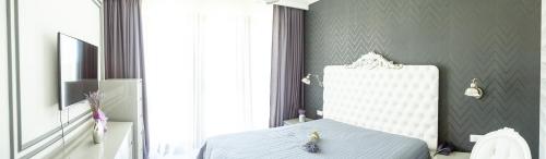 a bedroom with a bed and a white chair at Pensiunea Primaverii in Satu Mare