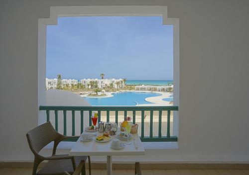 een tafel met eten en uitzicht op de oceaan bij Vincci Helios Beach in Midoun