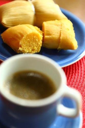 a blue plate with a cup of coffee and some food at Hospedaria Tayrona in Lençóis